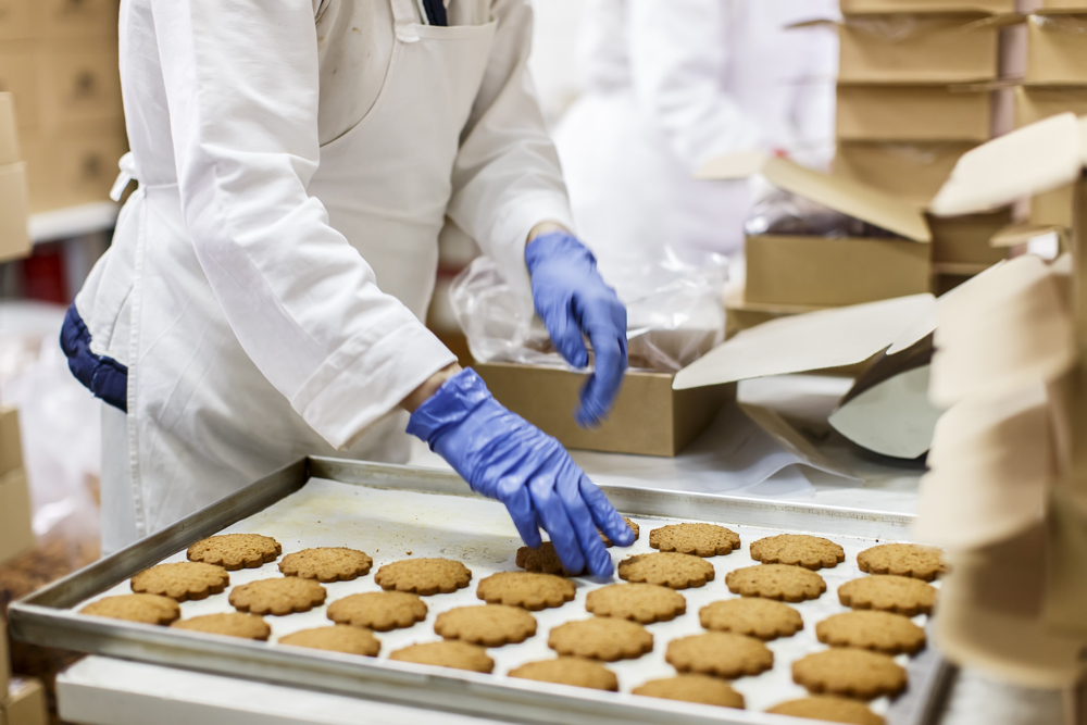 Chef removing freshly baked cookies from the baking tray